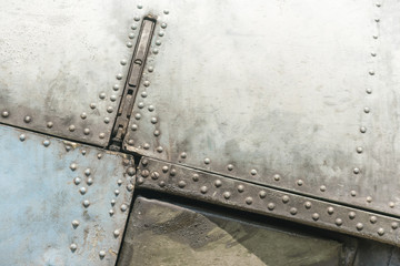 Old metal surface of the aircraft fuselage with rivets