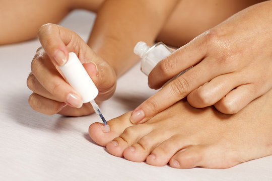 Fototapeta women applied nail polish on her toes