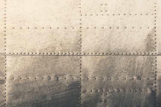 Old metal silver surface of the aircraft fuselage with rivets