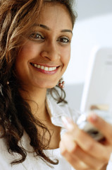 Woman using mobile phone, smiling