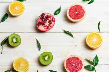 sliced fruit on wooden white background, top view