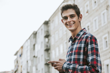 young man with mobile phone in the city