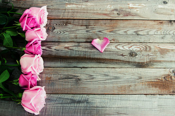 Seven roses on wooden background