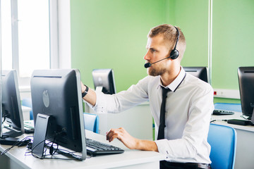 Joyful agent working in a call center with his headset