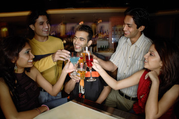 Young adults toasting drinks in club