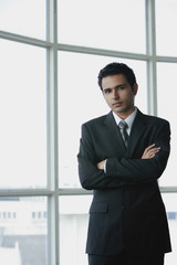 Fototapeta premium Young businessman arms crossed, looking at camera