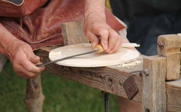 A Classic Craft Worker Shaping a Round Disc of Wood.