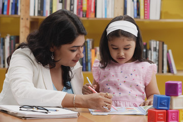 Woman and girl studying in library