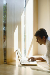 Man at home, using laptop