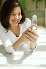 Woman looking at mobile phone, smiling