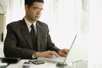 Businessman sitting at desk, using laptop