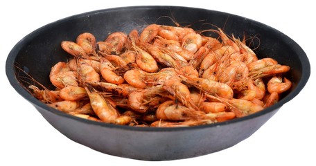 Black Sea shrimps, fried in black cast iron skillet. Isolated on white background