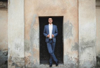 Obraz premium young groom stand near the wall