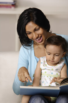 woman flipping picture book with baby