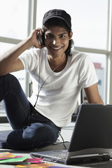 young man wearing headphones while on laptop