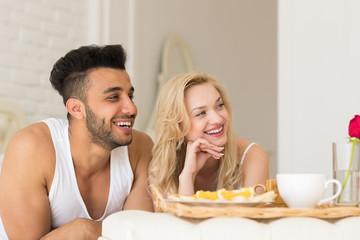 Obraz na płótnie Canvas Young Couple Lying In Bed Eat Breakfast Morning With Red Rose Flower, Happy Smile Hispanic Man And Woman Lovers In Bedroom