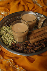 Indian masala tea with spices on silver tray.