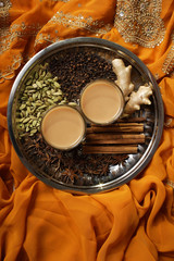Indian masala tea with spices on silver tray.