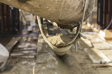 Cement truck is pouring cement into a foundation - obrazy, fototapety, plakaty