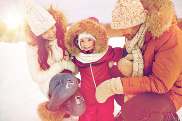 happy family with child in winter clothes outdoors