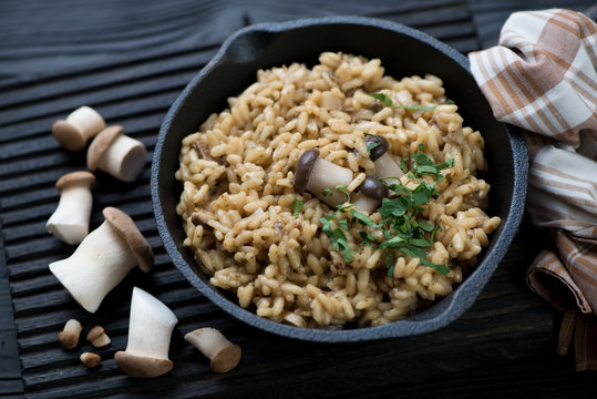 Risotto with wild mushrooms in a cast-iron skillet, close-up