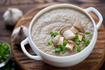 Close-up of a white glass tureen with porcini cream-soup