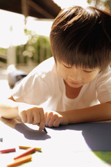 Young boy drawing with crayons