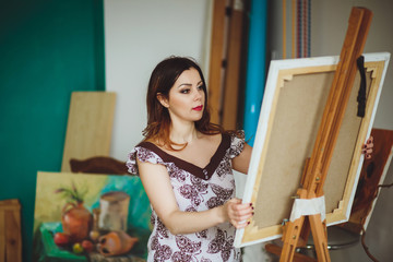 Woman artist painting a picture in a studio