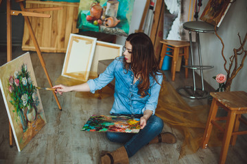 Woman artist painting a picture in a studio