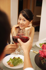 Friends at dinner table, toasting with wine glasses