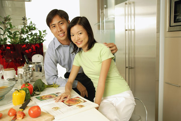 Couple in kitchen, looking at camera