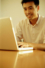 Executive using laptop, looking forward, toothy smile