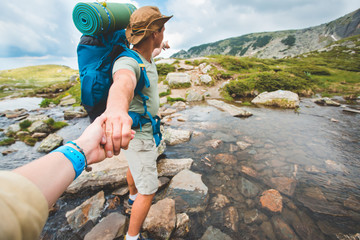 man and woman  crossing a river on stones