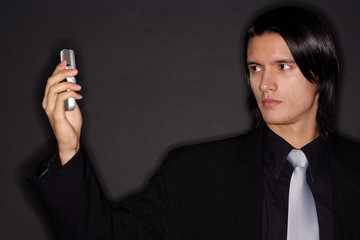 Executive holding mobile phone, photo messaging