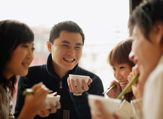 Group of friends eating at a Chinese restaurant, side by side