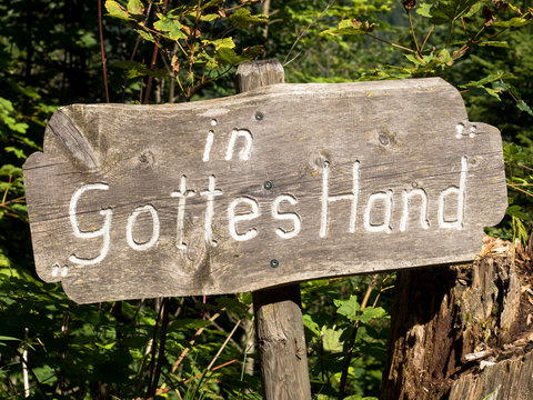 Schild mit Aufschrift in Gottes Hand