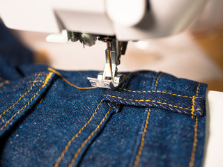 Jeans wird mit Nähmaschine genäht