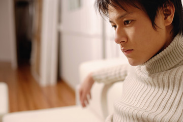 Young man sitting, looking down