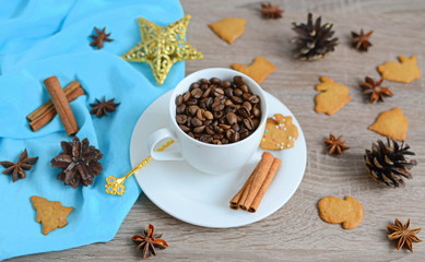 Fototapeta na wymiar Cup of coffee beans with christmas decorations on wooden table 