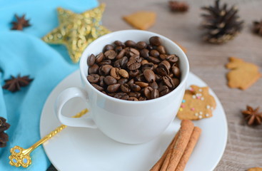 Cup of coffee beans with christmas decorations on wooden table
