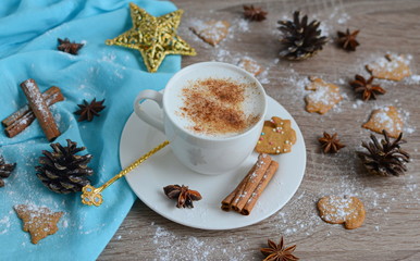 Cup of cappuccino with christmas decorations on wooden table
