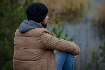 Outdoor Portrait of a handsome brutal man with beard and mustache dressed in winter clothes, covered with frost.Hipster fashion man. Casual winter fashion