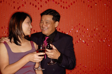 Couple looking at each other, holding wine glasses