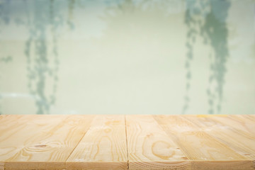 Empty wooden table platform with over blurred silhouettes on the curtains background for presentation product...