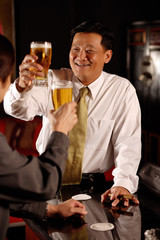 Two men raising beer glasses