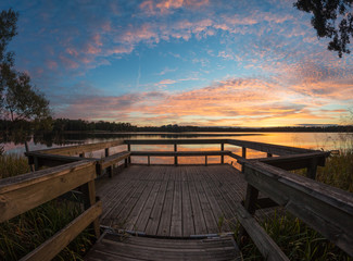 Wooden pier on lake sunset.