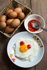 Fried egg on cooked rice and fresh eggs.