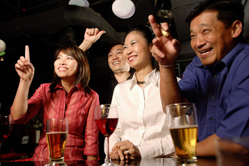 Couples at bar, making hand signs