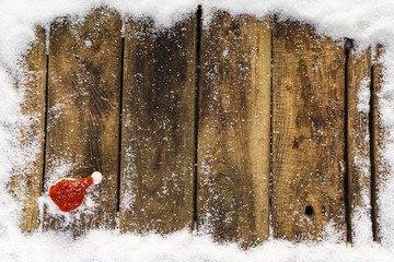 Weihnachtsmütze auf verschneiten Holzbrettern, Topview