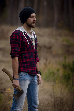 Portrait brutal bearded hipster man in the forest